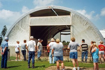 Sustainable Crop and Livestock Systems People listening to a farmer in front of a hoop structure